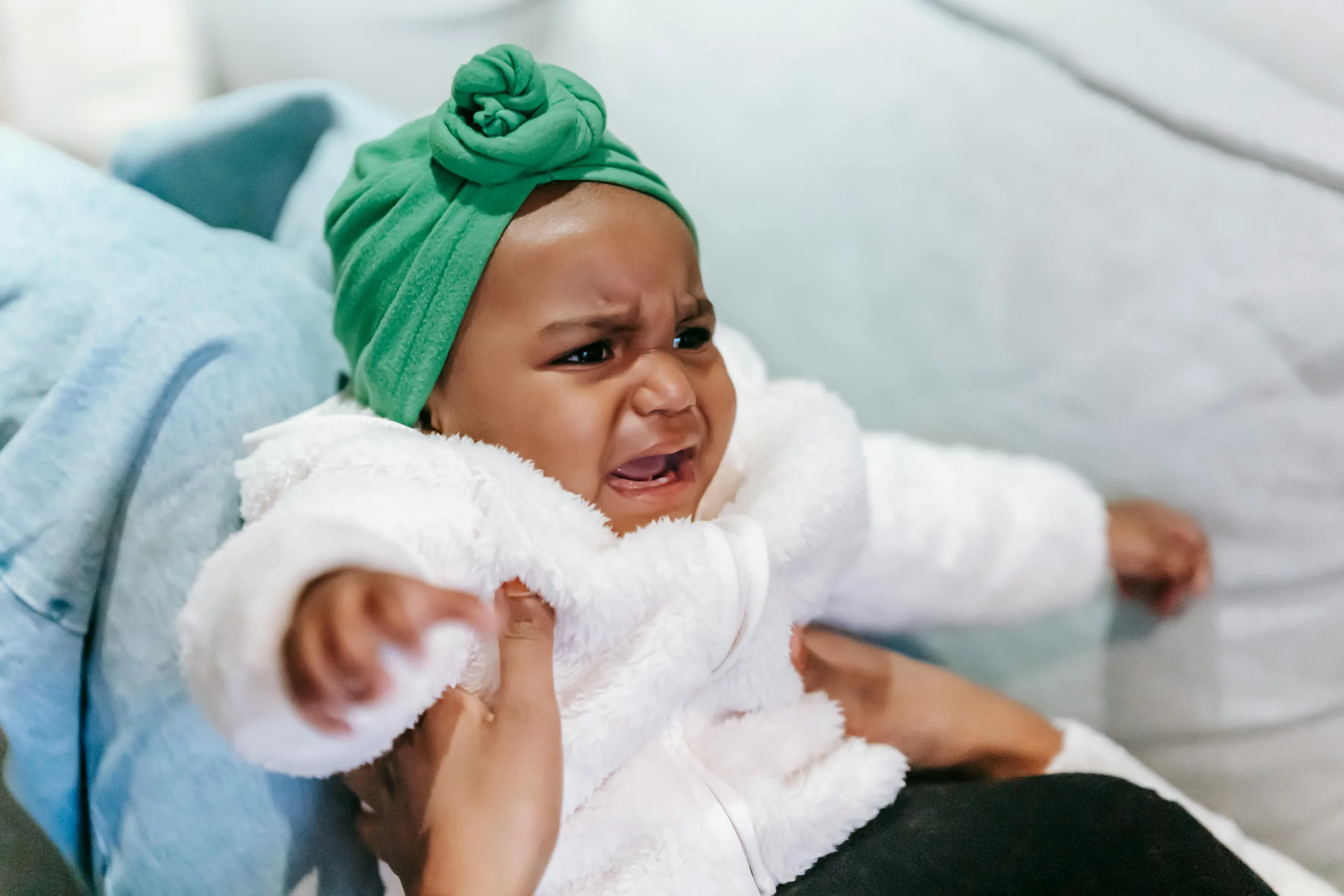 Un bébé fille pleure sur les genoux de sa maman